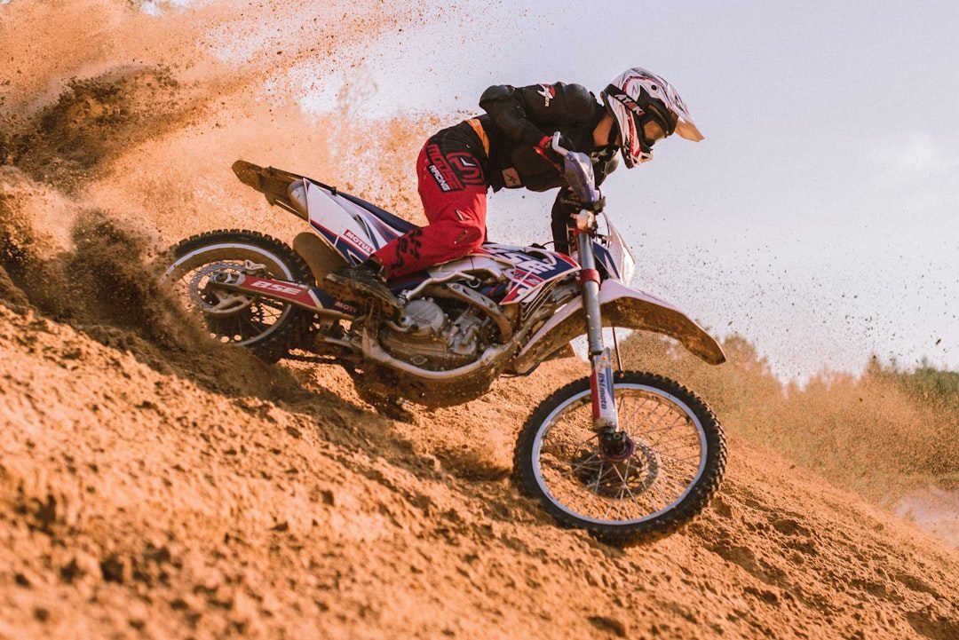Electric dirt bike rider kicking up dust on a trail