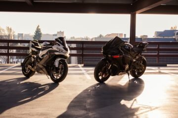 Two electric dirt bikes parked side by side for comparison